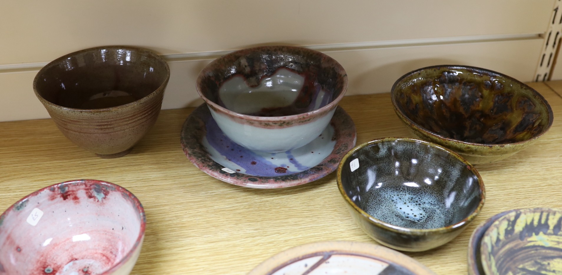 A large pottery figural tile together with a collection of studio pottery bowls